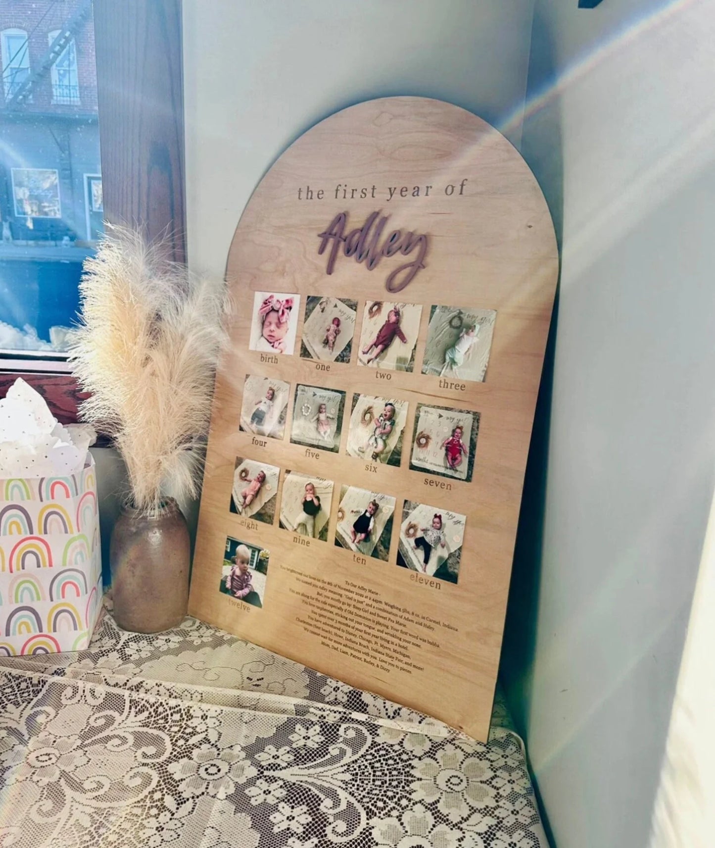 the first year of Adley wooden sign with baby pictures of each month