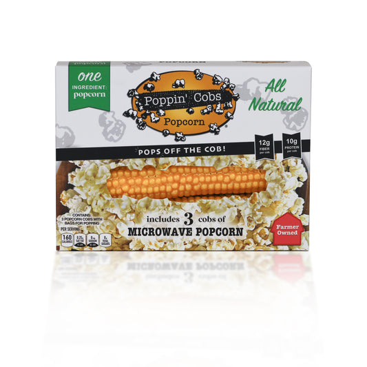 Packaging for Poppin' Cobs natural popcorn, showing three popped popcorns, with labels indicating the product is all natural, non-GMO, and contains 3 cobs of microwave popcorn.