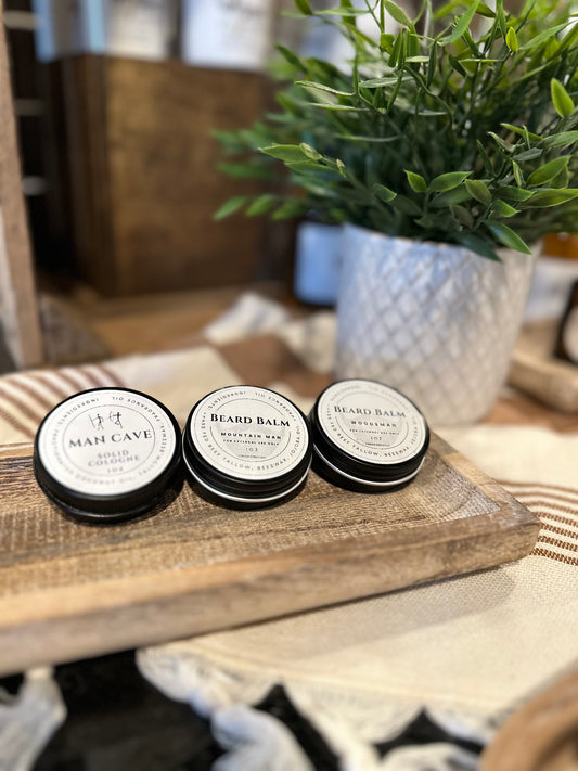 Three Beard Balm containers on wooden tray with various decorations