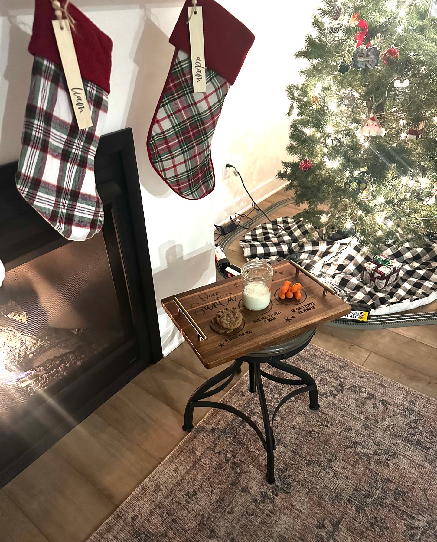Christmas stockings hanging by a fireplace with a decorated tree in the background.