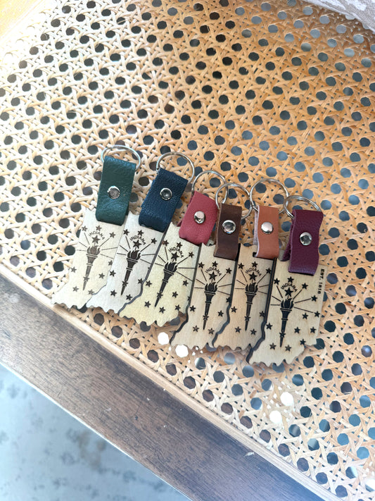 Set of keychains with different colored straps on a perforated metal surface.