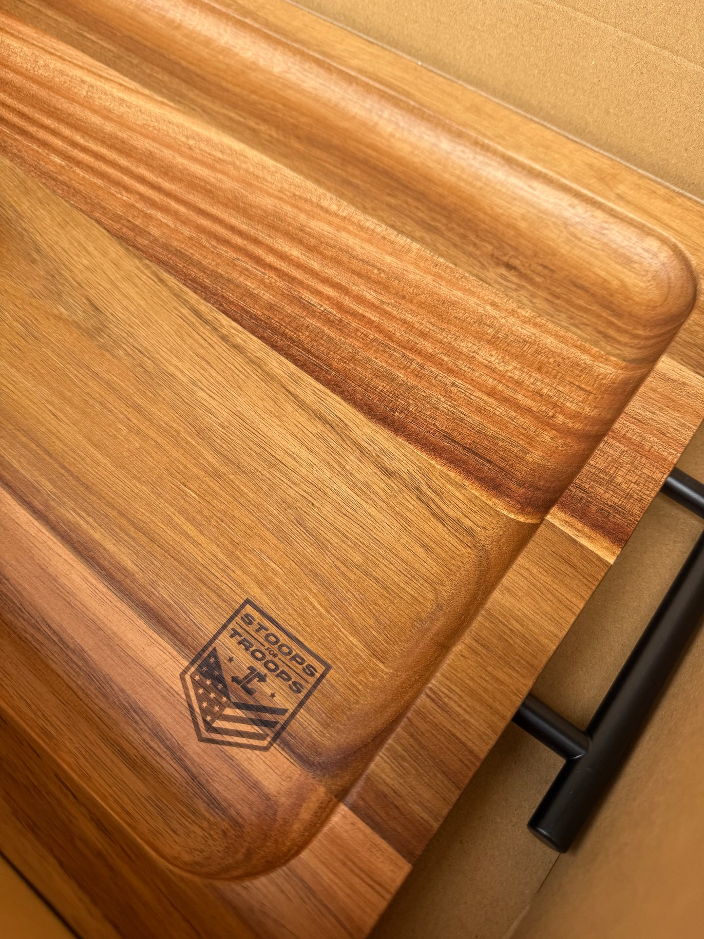 Wooden cutting board with a visible logo on a wooden surface
