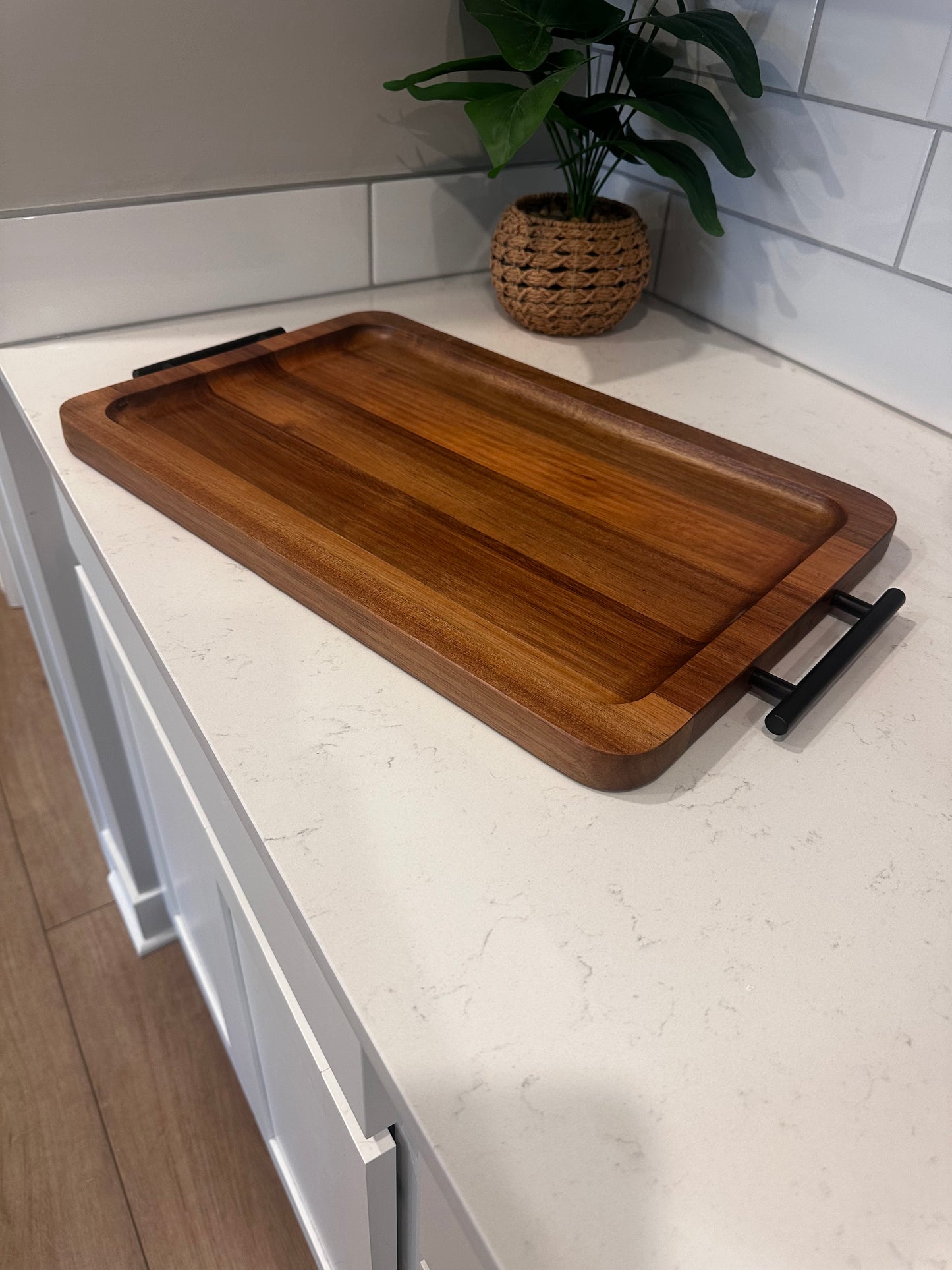 Wooden cutting board with a handle on a white countertop