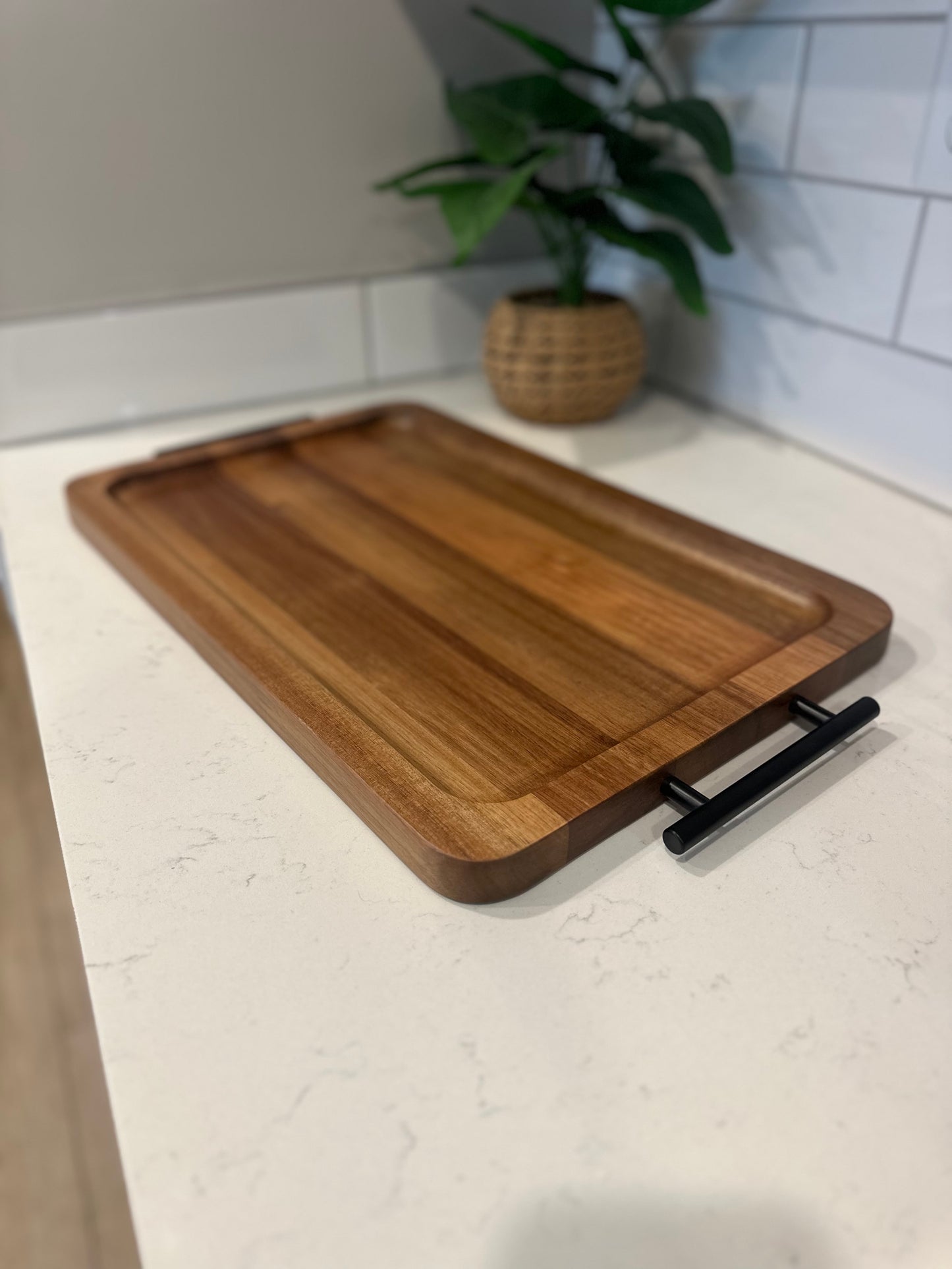 Wooden cutting board with a handle on a kitchen counter