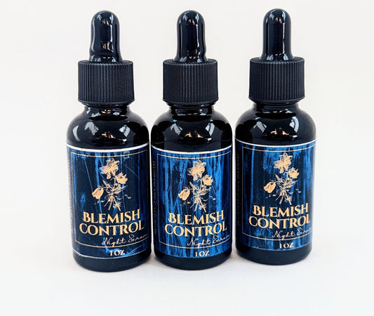 Three blemish control night serum bottles with white background