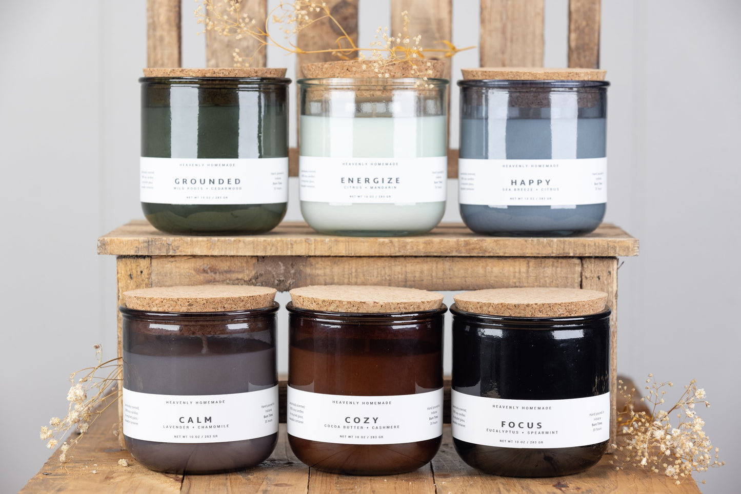 6 candles of all different scents lined up on wooden boxes