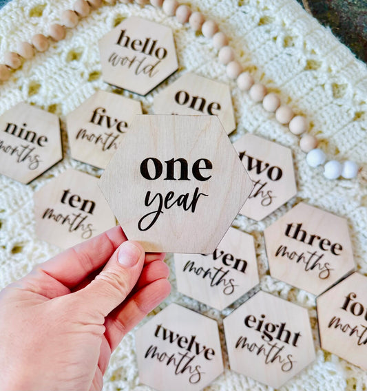 Milestone marker wooden cutout, hand holding the one year