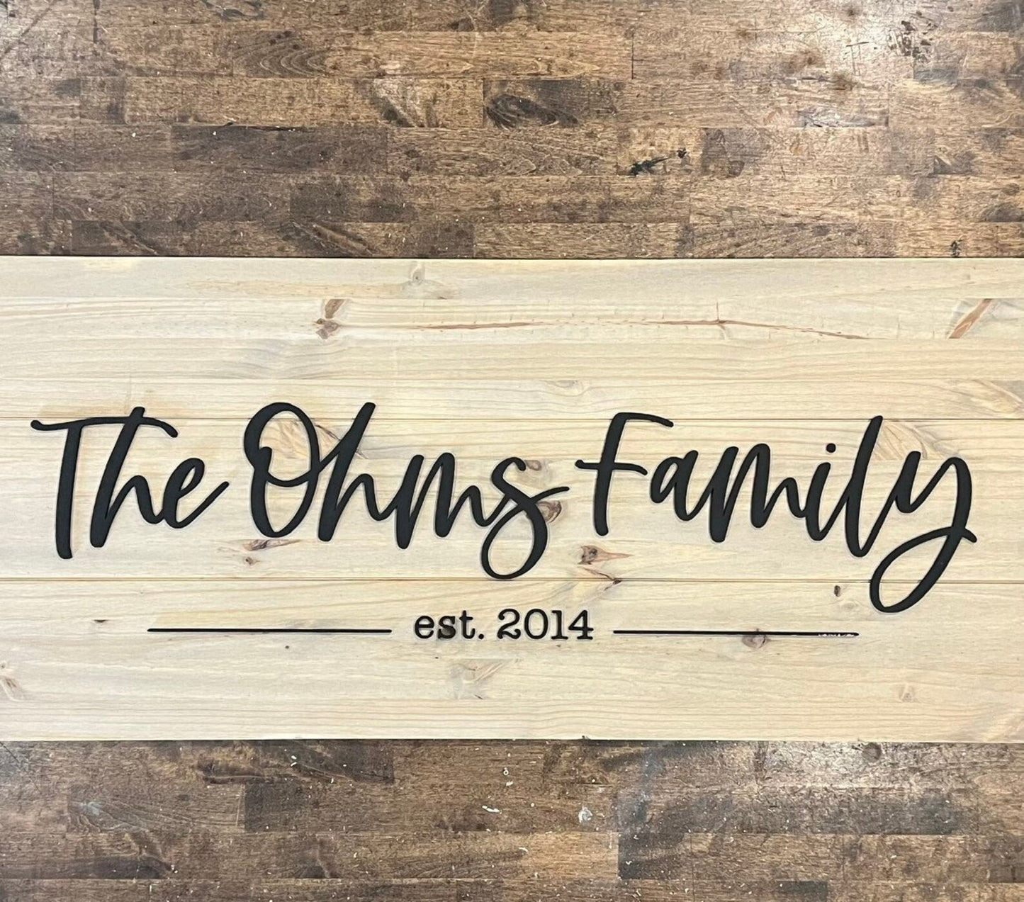 Wooden family name sign against wood floor background