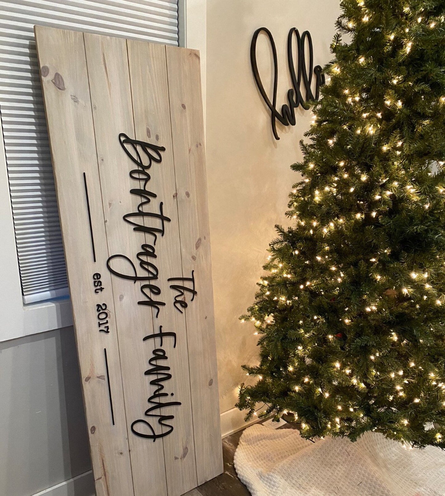 Wooden Family Name Sign on its side in front of christmas tree