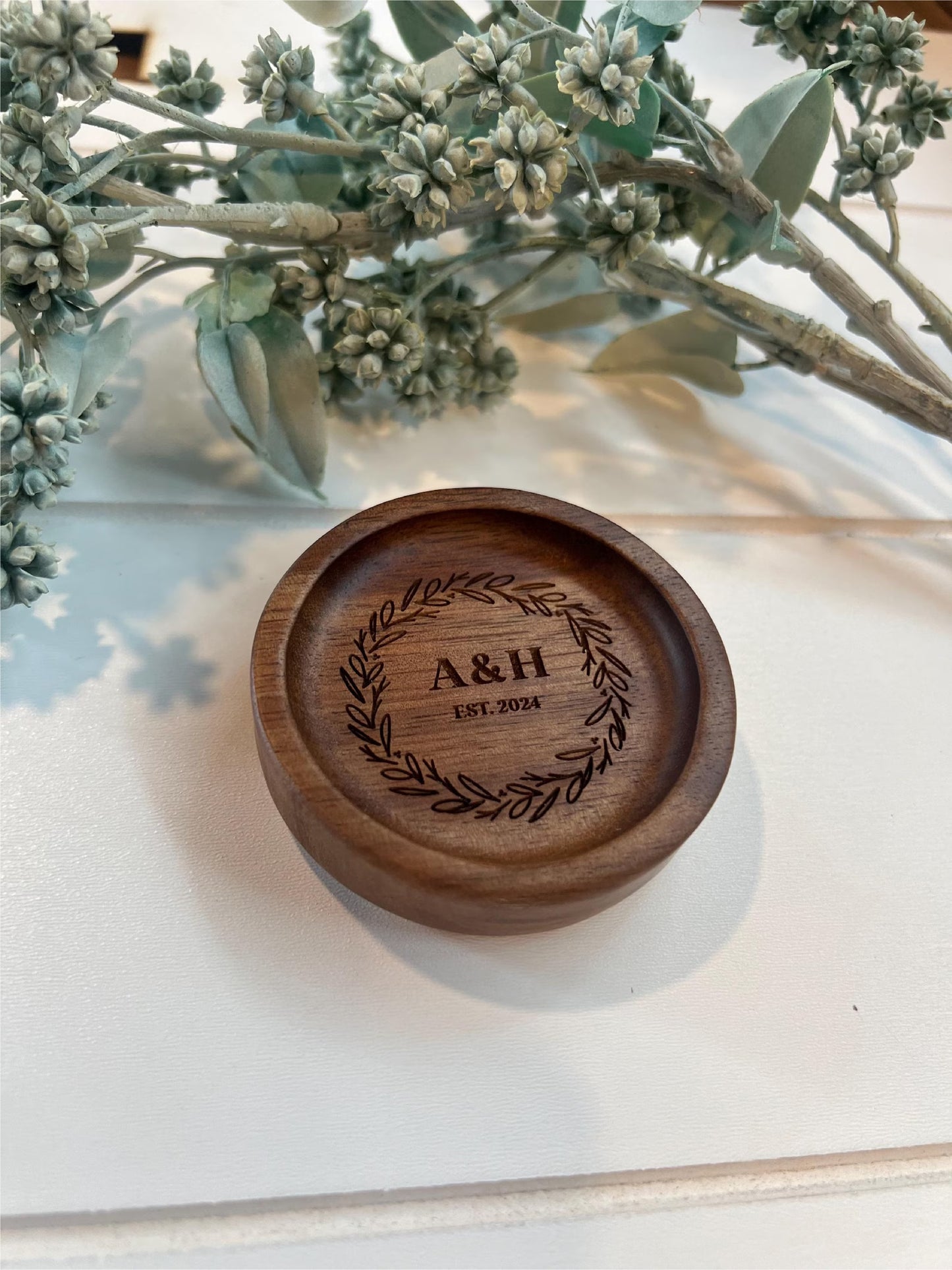 personalized wooden ring dishes with various designs, each with a different name and wedding date inscribed on it.
