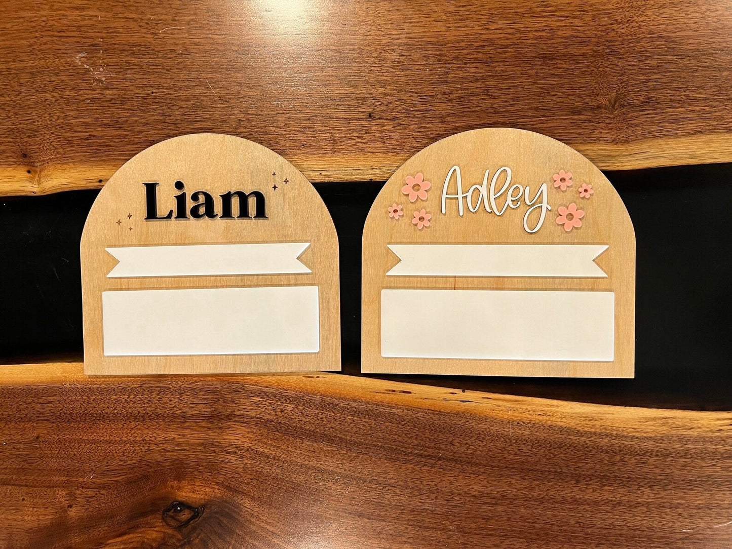 Liam and Adley Back to School Signs next to each other on wooden table