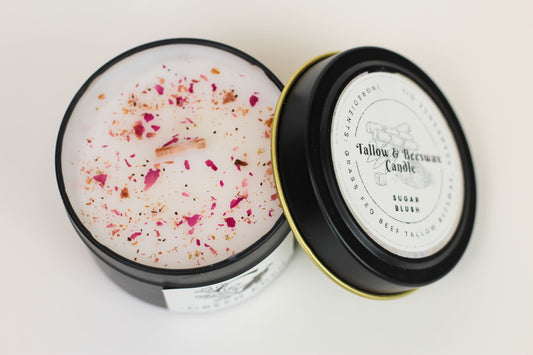 An open jar of Green Eden candle with a 'Sugar Blush' label, showing the wax melt and sugar blush mixture inside, surrounded by dried sugar blush petals.