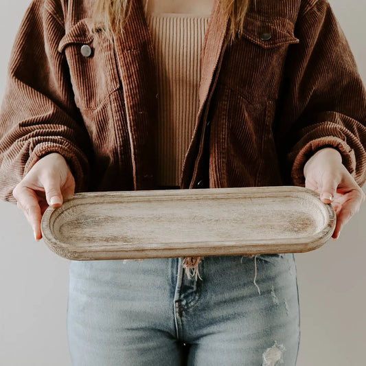 Woman holding wood tray with two hands