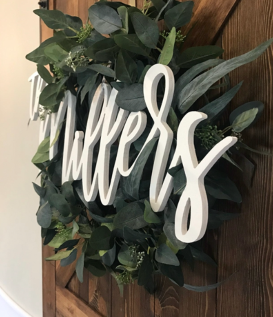 Large wooden name sign hung up on wall.