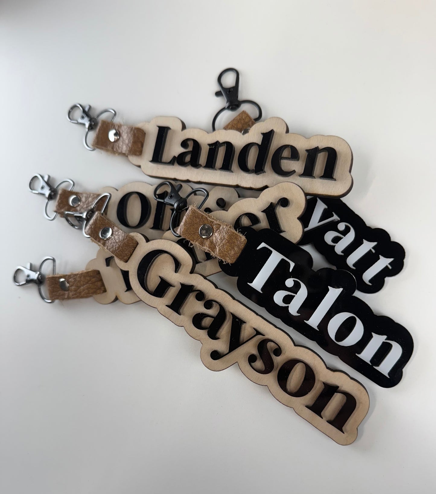 Personalized name tags with leather straps on a white background