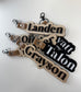 Personalized name tags with leather straps on a white background