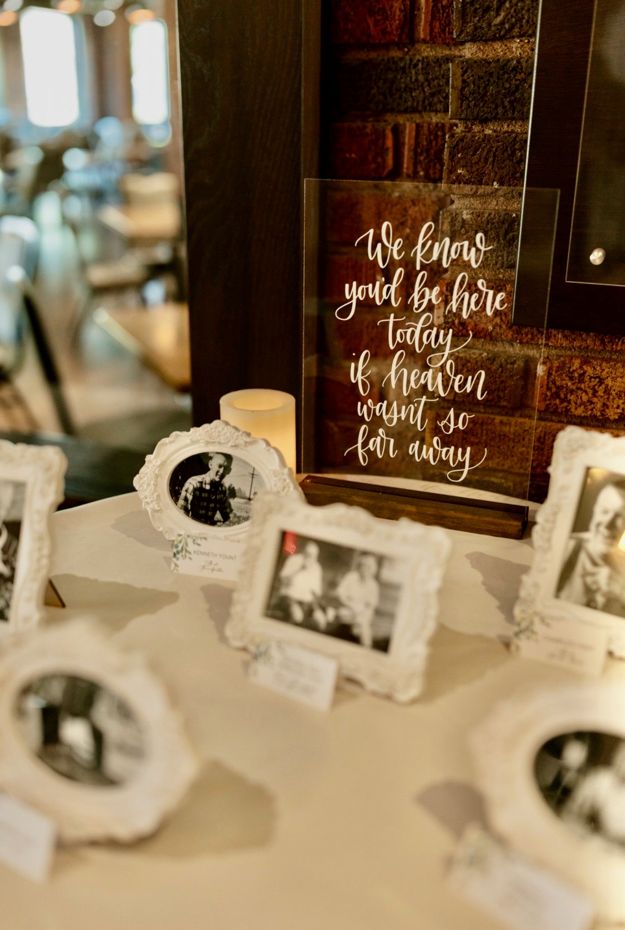 Decorative setup with framed photos and a sign on a table.