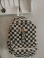Black and white checkered backpack with 'Rhett' brand tag hanging on a hook.