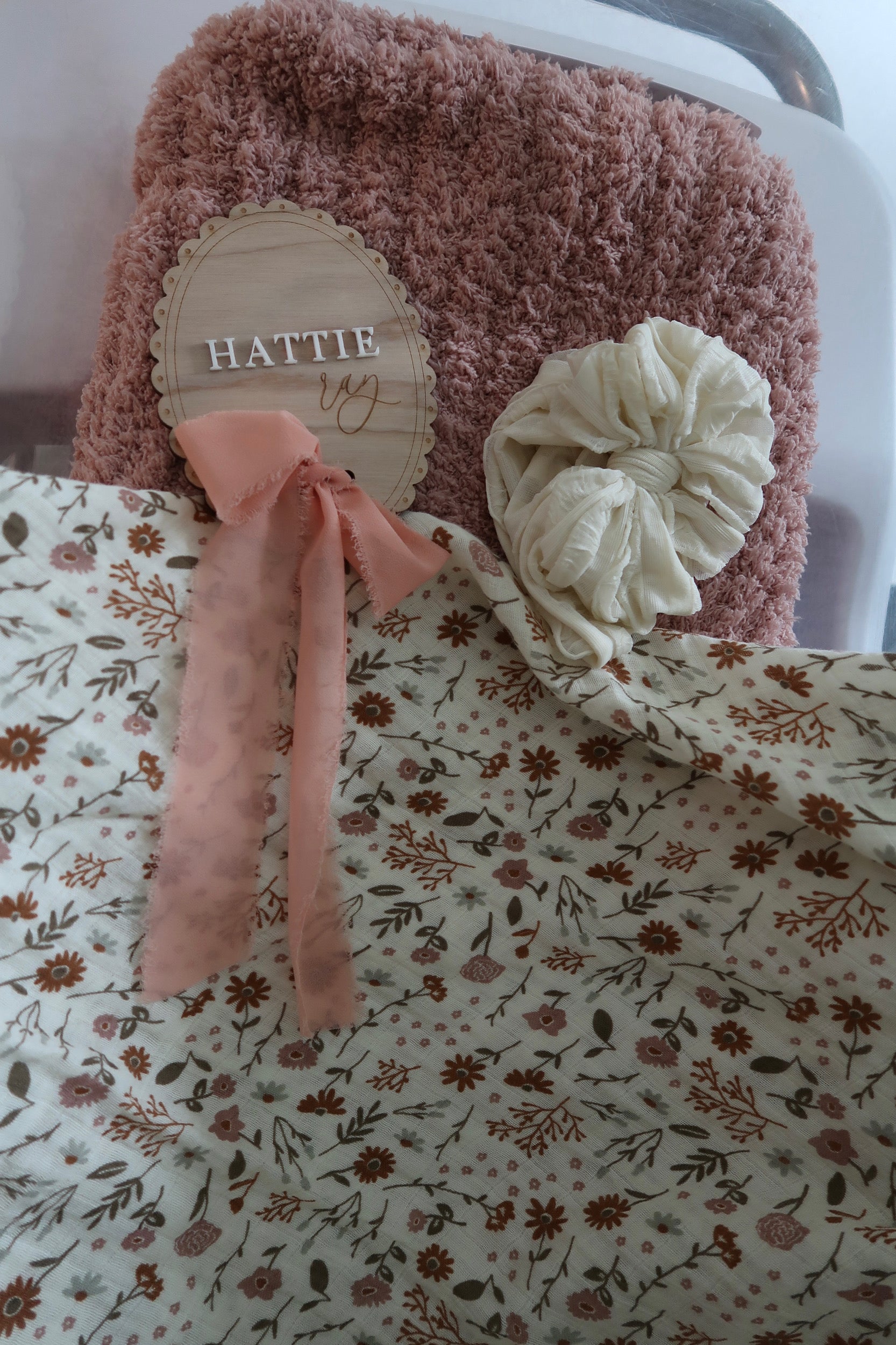 Floral Swaddle, pink blanket, white baby headband, and Hattie Ray baby announcement 